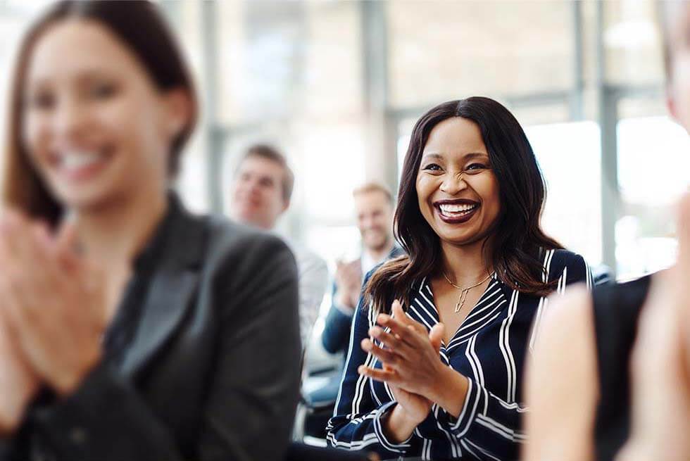 Work team standing and clapping during meeting